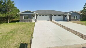 A two-story house with a garage, a driveway, and a well-maintained lawn. - Relax & Recharge in Perham's Lakes Country ~ Family-friendly 3BR Retreat (Perham)
