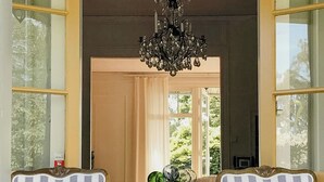 A room with two striped chairs, a chandelier, and a view through a door. - Charming artist's house in Söderåkra (Söderåkra)