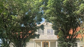 A white building with a porch, surrounded by trees and a gravel path. - Charming artist's house in Söderåkra (Söderåkra)