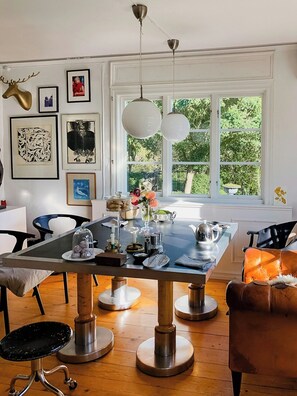 A dining area with a large table, chairs, and a window with a view of greenery. - Charming artist's house in Söderåkra (Söderåkra)
