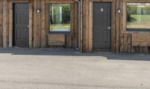 A wooden building with two doors, each with a window above.