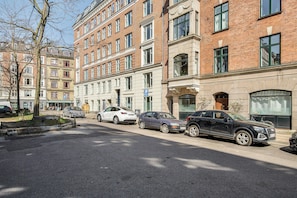 A street with parked cars, a tree, and multi-story buildings with windows and doors. - Historic apartment in the heart of Østerbro (København)