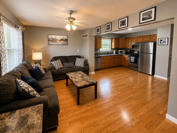 A living room with a sofa set, a coffee table, and a ceiling fan.