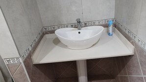 A bathroom with a white sink, a faucet, and a soap dispenser. - J & J Paradise Guesthouse  (Pietermaritzburg)