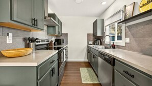 Una cocina moderna con armarios grises, electrodomésticos de acero inoxidable y una isla grande.