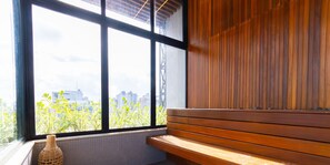 Ein Zimmer mit einem großen Fenster, einer hölzernen Bank und einem gewebten Korb.