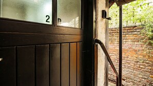 A wooden door with a glass panel, a number '2' on it, and a brick wall in the background. - Central Chester Recently Renovated 1BR Flat (Chester)