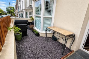 A patio with a table and chairs, potted plants, and a small garden area. - 1 Bed - Sleeps 4 - Parking - Pets - Town Centre (Wadebridge)