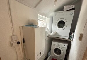 A compact laundry room with a washing machine, dryer, and a utility room with a telephone. - 1 Bed - Sleeps 4 - Parking - Pets - Town Centre (Wadebridge)