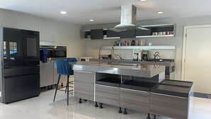 A modern kitchen with a central island, built-in appliances, and a bar stool. - Amazing 6-bedroom house with AC in adorable Bethesda (Bethesda)