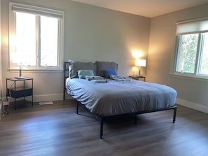 A bedroom with a bed, bedside tables, and a window. - Amazing 6-bedroom house with AC in adorable Bethesda (Bethesda)