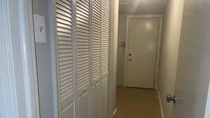 A hallway with a white door at the end, a white wall, and a light switch on the left. - Amazing 6-bedroom house with AC in adorable Bethesda (Bethesda)