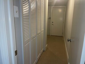 A hallway with a white door at the end, a white wall, and a light switch on the left. - Amazing 6-bedroom house with AC in adorable Bethesda (Bethesda)