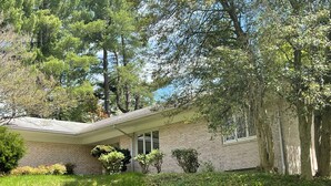 A single-story house with a brick exterior, a covered porch, and a well-maintained lawn. - Amazing 6-bedroom house with AC in adorable Bethesda (Bethesda)