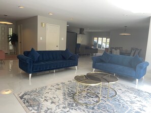 A modern living room with two sofas, a glass coffee table, and a patterned rug. - Amazing 6-bedroom house with AC in adorable Bethesda (Bethesda)