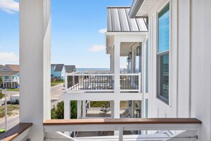 A multi-story building with balconies, a wooden deck, and a view of the ocean. - Summer Open! 1 Min Walk to Beach, Pool & Spa (Ocean Isle Beach)