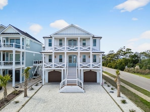 Une maison à deux étages avec un porche à l’avant, un garage et une allée.