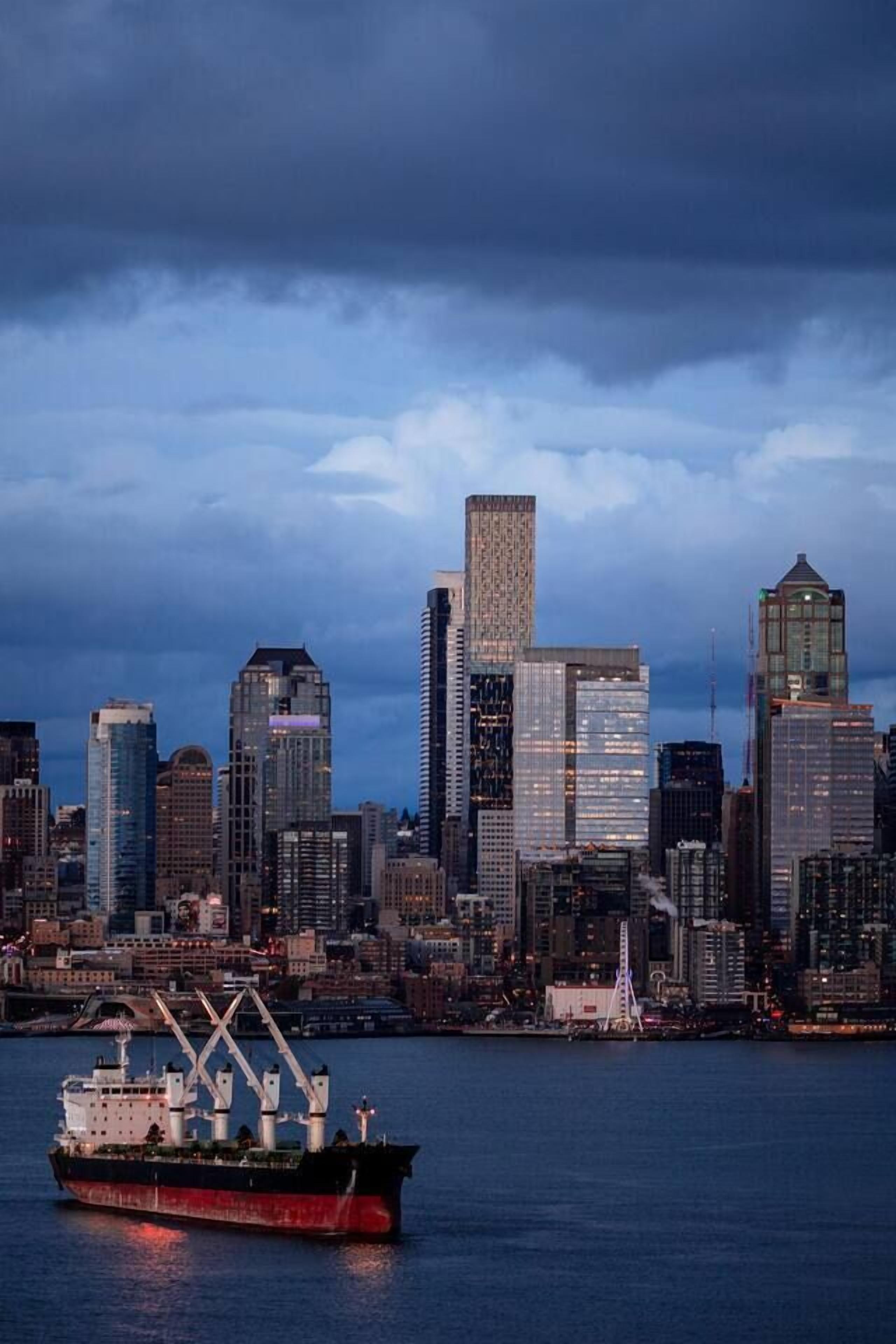 Une vue sur les grat-ciel d’une ville, avec des bâtiments modernes et un grand navire au premier plan.