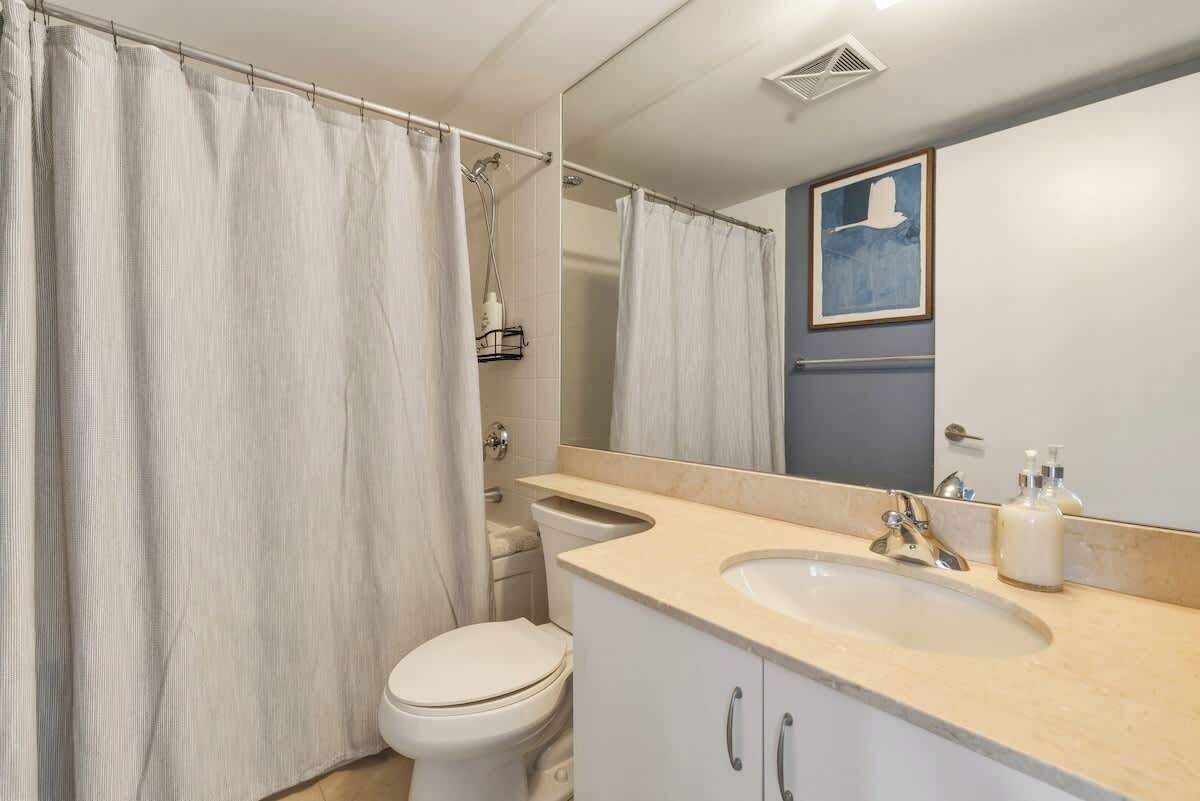 A second full bathroom with a shower-tub combo and fresh towels.