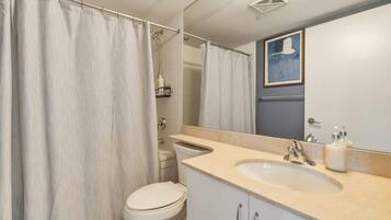 A second full bathroom with a shower-tub combo and fresh towels.