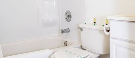 Un baño con bañera, inodoro y espejo.