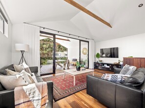 Ein modernes Wohnzimmer mit Sofa, Couchtisch und Fernseher.