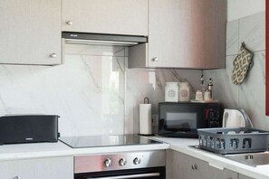 Eine moderne Küche mit Herd, Mikrowelle und Geräten auf der Arbeitsfläche.