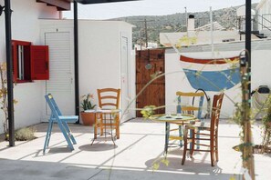 Eine Terrasse mit Gartenmöbeln, einem Boot und einer Tür.