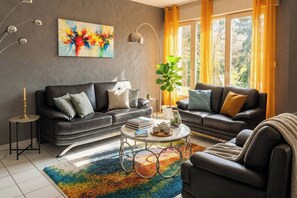 Ein modernes Wohnzimmer mit zwei Sofas, einem Couchtisch und einer Stehlampe.
