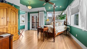 Une chambre à coucher avec un lit à baldaquin, des meubles en bois et un ventilateur de plafond.