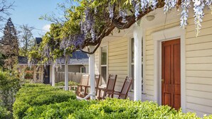 A house with a porch, wooden chairs, and a well-maintained garden. - Whimsy on B | 2BR Steps to Downtown (Ashland)