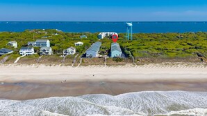 Ein Küstengebiet mit direktem Strandzugang, einem Wasserturm und mehreren Häusern.