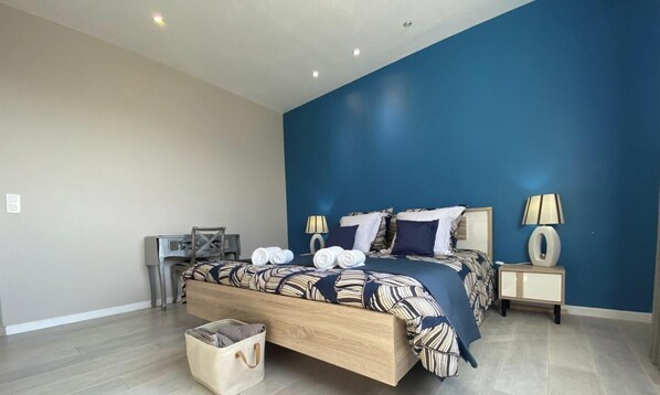 A bedroom with a bed, bedside tables, a lamp, and a bag on the floor. - Bonica Vista - 6 people (OMS)