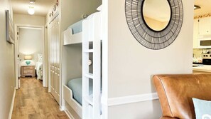 A hallway with bunk beds, a mirror, and a kitchen area. - Horizon South 75C Resort-style (Panama City Beach)