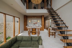 Ein modernes Interieur mit Küche, Essbereich und Treppe.