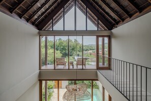 A modern interior with a high ceiling, large windows, and a view of greenery outside. - Cozy villa, prime Uluwatu, actual walking distance (Badung Regency)