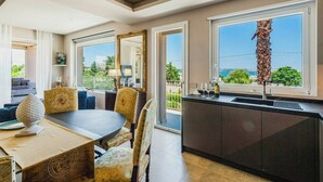 Una cocina moderna con un ventanal grande, un comedor con una mesa redonda y vistas a zonas verdes.