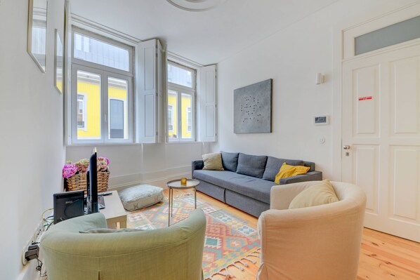 A living room with a sofa, armchairs, a small table, and a TV. - Cedofeita Hidden Patio (Porto)