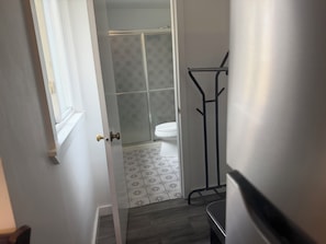A bathroom with a toilet, shower, and a towel rack.