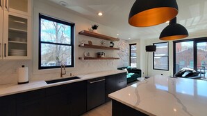 Una cocina moderna con una isla grande, estanterías empotradas y vistas a la ciudad.