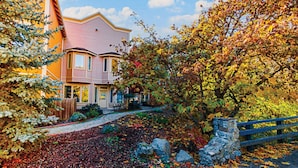 A two-story house with a stone pathway leading to the front door, surrounded by autumn foliage and a wooden fence. - Jackson Creek: Downtown Jacksonville (Jacksonville)