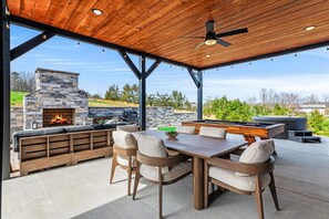 An outdoor patio with a stone fireplace, seating, and a pool table. - New 2026-MT Views-1 step entry-5 mi to Dolly-Pets (Sevierville)