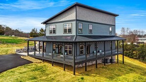 Une maison à deux étages, dotée d’un porche couvert et de fondations en pierre.