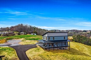 A two-story house with a covered porch and a driveway leading to it. - New 2026-MT Views-1 step entry-5 mi to Dolly-Pets (Sevierville)