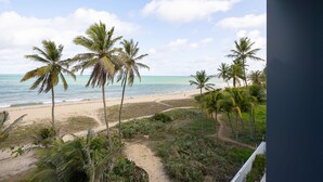 A beach view with palm trees and a sandy path leading to the water. - Breeze #407 - Double Sea View By Carpediem (João Pessoa)
