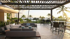 A covered outdoor seating area with a view of the ocean, furnished with sofas and tables. - Big Island Resort Stay Near Beaches with Spacious 2BR Island View (Waikoloa Village)