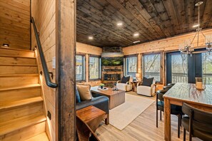A wooden interior with a staircase, seating area, fireplace, and large windows. - LUXE-Mtn Views-1 mi to PKWY-Pool-Rooftop Bar-Pets (Pigeon Forge)