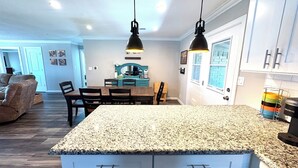 A kitchen with granite countertops, white cabinets, and pendant lighting. - The Grape Stay of Texas- in the heart of Grapevine Main Street (Grapevine)