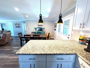 A kitchen with granite countertops, white cabinets, and pendant lighting. - The Grape Stay of Texas- in the heart of Grapevine Main Street (Grapevine)