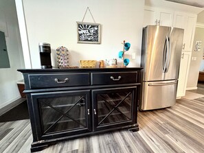 A kitchen with a black cabinet, a stainless steel refrigerator, and a wall-mounted sign. - The Grape Stay of Texas- in the heart of Grapevine Main Street (Grapevine)